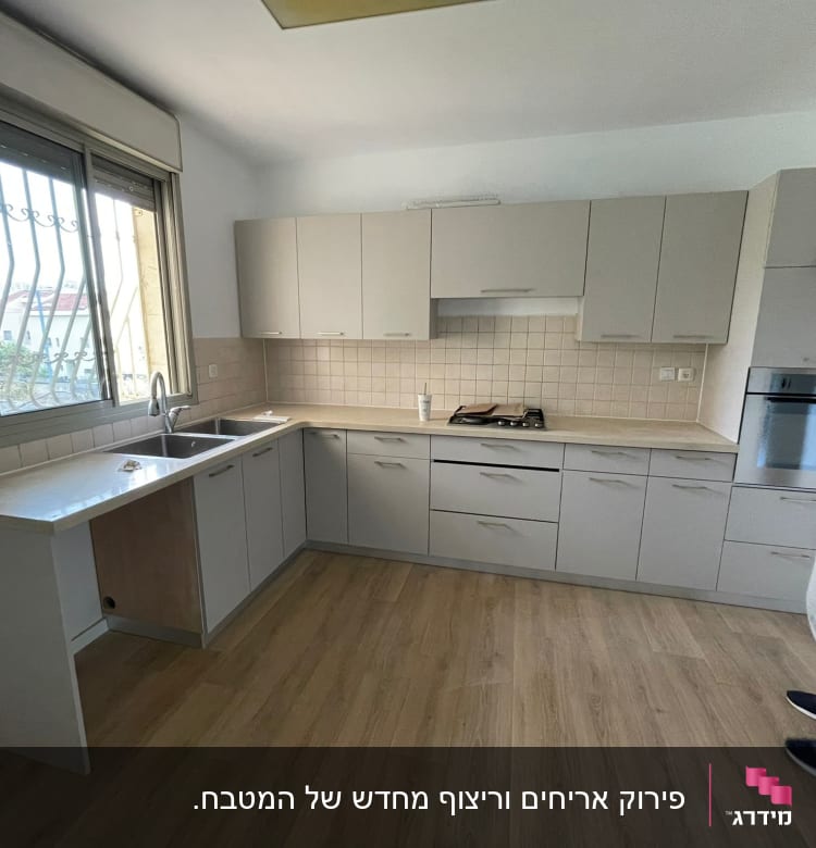 מטבח משופץ עם ארונות חדשים ואדם בודק ארון